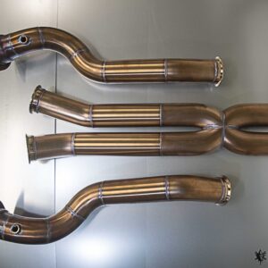 Top-down view of a custom Ferrari FF and GTC4Lusso exhaust system featuring downpipes and an X-pipe by Fluid MotorUnion